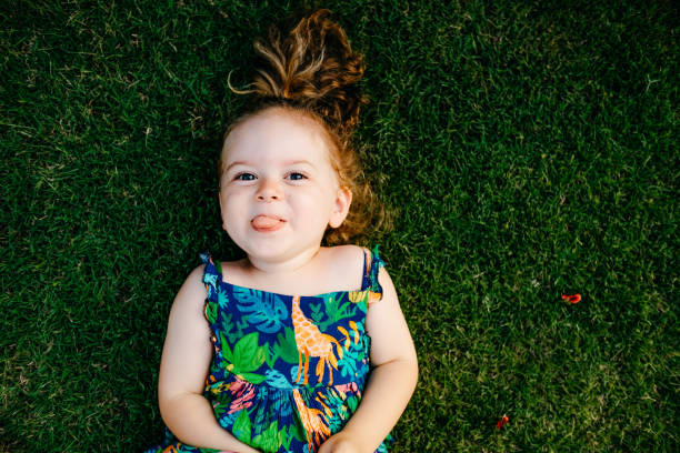 istock Happy Smiling Little Girl Lying On Grass 1179554583