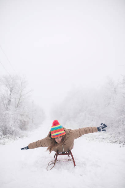 young woman sledging in deep snow and have fun, concept winter and sleigh ride