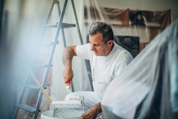 istock Male painter mixing paint at home 1179554964