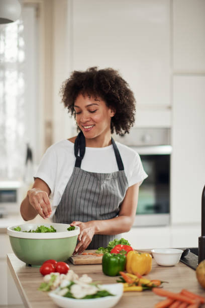 istock Woman putting lettuce in bowl. 1179556013