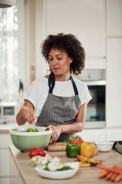 istock Woman putting lettuce in bowl. 1179556476