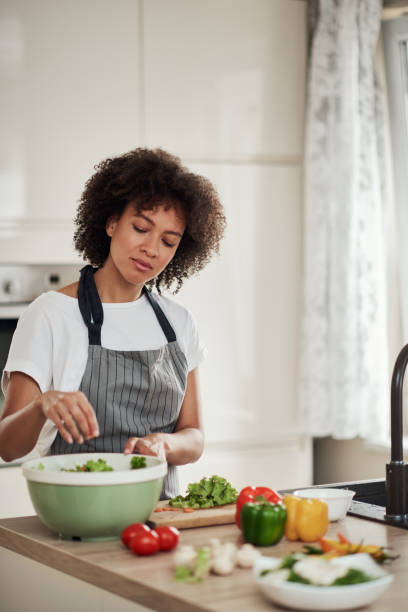 istock Woman putting lettuce in bowl. 1179557142