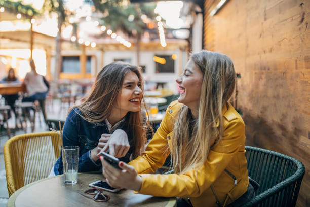 istock Young women gossiping outdoors in cafe 1179557243
