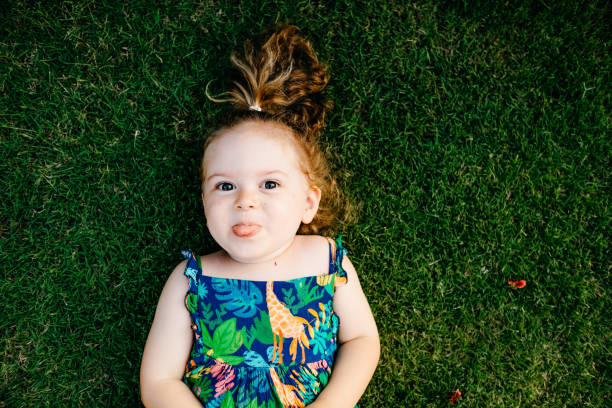istock Happy Smiling Little Girl Lying On Grass 1179557302