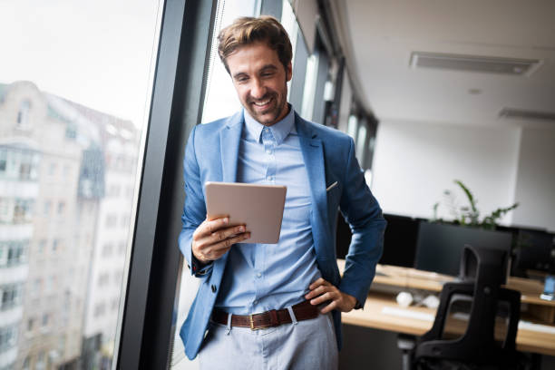 istock Portrait of young businessman smiling while using digital tablet in office 1179560702