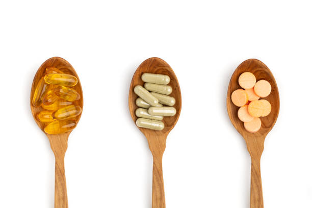 木製のスプーンの上のビューの丸薬と白い背景に隔離されたビタミン - capsule pill white nutritional supplement ストックフォトと画像