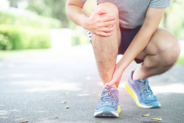 Jogging, leg painThe  took the hand to the ankle with motion pain stock photo