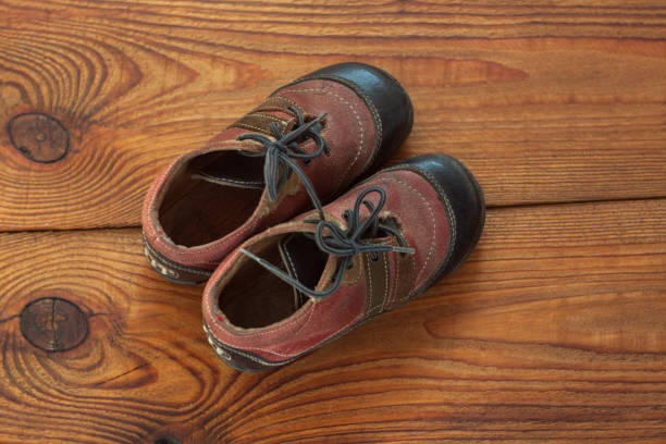 istock Leather kids boots on a wooden background top view with copy space. 1179561812