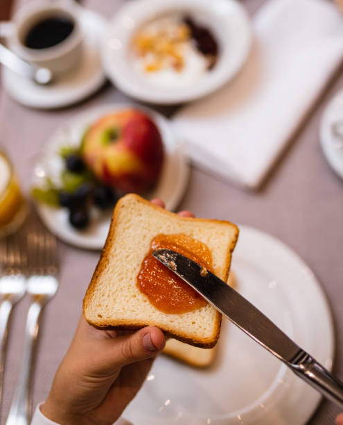 istock Young woman spreading jam on a toast 1179561954