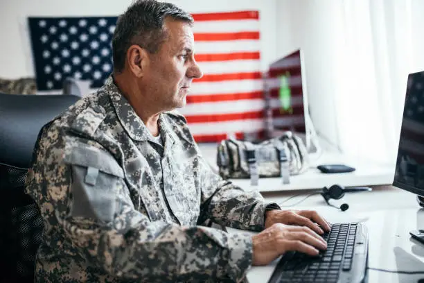 Army solider working on the computer in the office