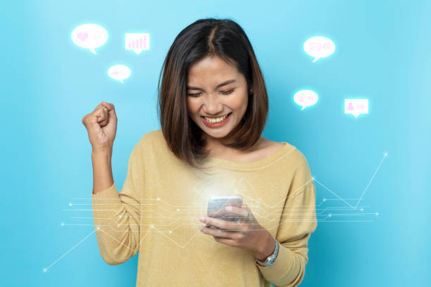 istock portrait asian young Women are happy while using smartphone on blue background 1179563430