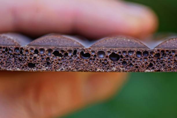 istock fingers hold a piece of brown chocolate 1179564339