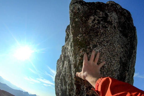 istock POV of man's hands climbing boulder 1179565295