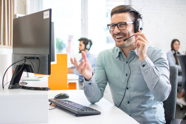 feliz operador de soporte técnico con auriculares que trabajan en el centro de llamadas - inside of office technology people fotografías e imágenes de stock