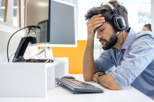 istock Young handsome operator man wearing call center headset suffering from headache 1179567421