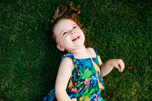 istock Happy Smiling Little Girl Lying On Grass 1179567477