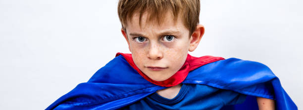 istock scared frowning superhero child escaping from bully, copy space white background 1179569733