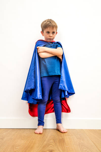 lost little superhero child with arms folded thinking about sadness lost little superhero child with arms folded thinking about anger, sadness, frustration or problem, low angle view denigrate stock pictures, royalty-free photos & images