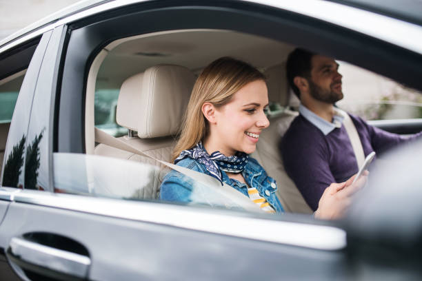 istock Happy young couple sitting in car, using smartphone. 1179570443