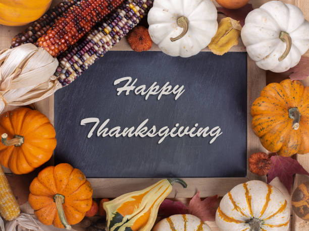 istock Happy Thanksgiving Text On Blackboard With Pumpkins and corn 1179571702