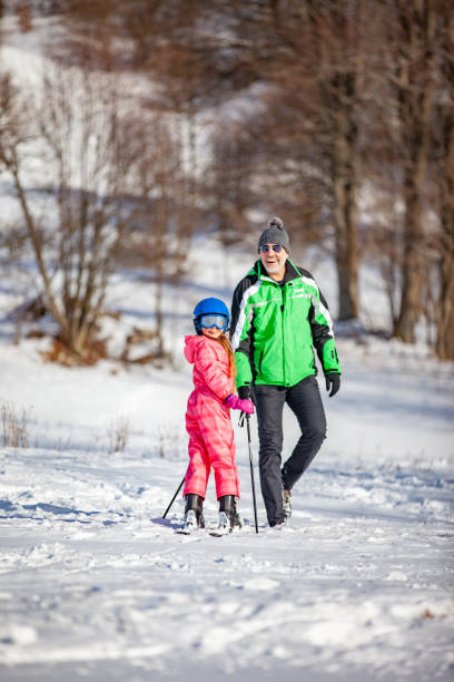 istock Smiling Father and Daughter Enjoying on Ski Slope 1179573548