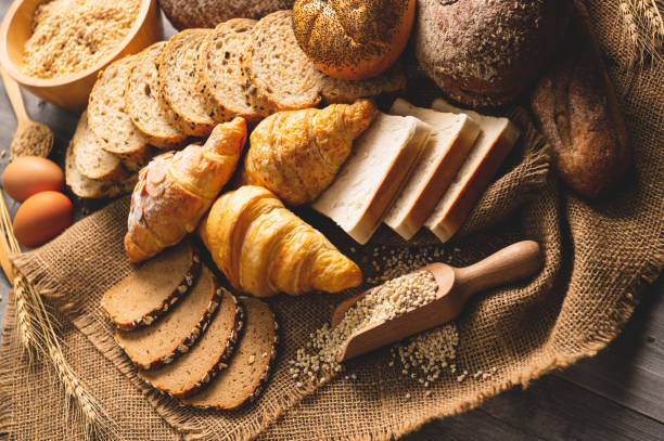 tipos diferentes do pão com grões inteiras da nutrição no fundo de madeira. alimento e padaria no conceito da cozinha. delicioso café da manhã gouemet e refeição. - bakery bread carbohydrate cereal plant - fotografias e filmes do acervo