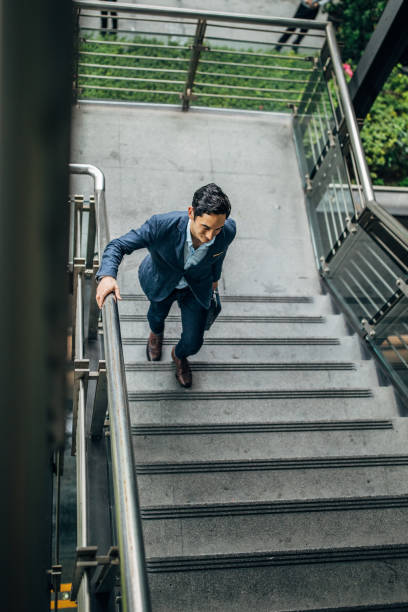 istock Businessman walking up the steps downtown in Taipei 1179575416