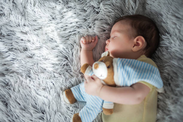 istock Baby boy sleeping with teddy bear 1179579877