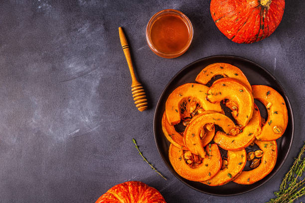 istock Baked slices of pumpkin on a dark background 1179580029