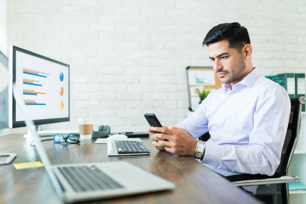istock Young Hispanic Businessman Using Smartphone At Desk 1179581739