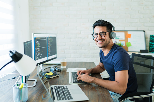 Confident Hispanic Software Developer Tying On Keyboard photo