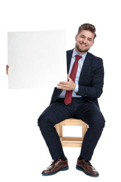istock happy young businessman holding empty white board 1179583401