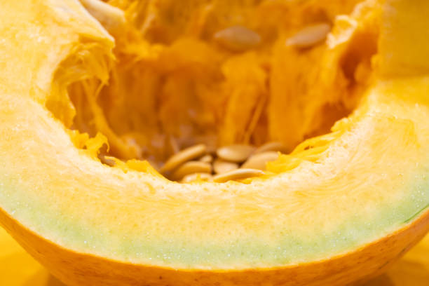 cut juicy yellow pumpkin close-up with drops of water