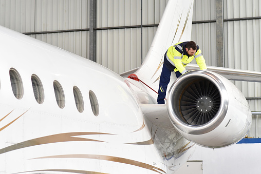 El mecánico de aeronaves inspecciona y comprueba la tecnología de un avión en un hangar en el aeropuerto photo