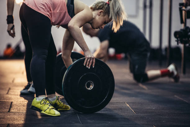 istock Woman lifting weights in gym 1179585569