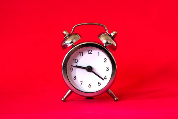 istock Alarm clock in retro vintage style on red background. Minimal modern style 1179586424
