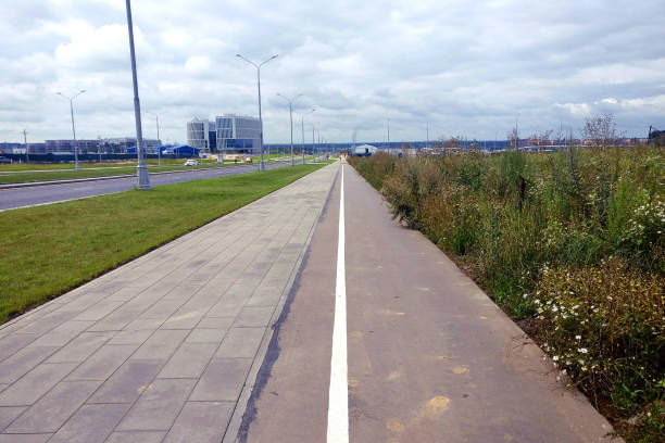 footpath of paving slabs and a strip for bicycle - rumble strip imagens e fotografias de stock