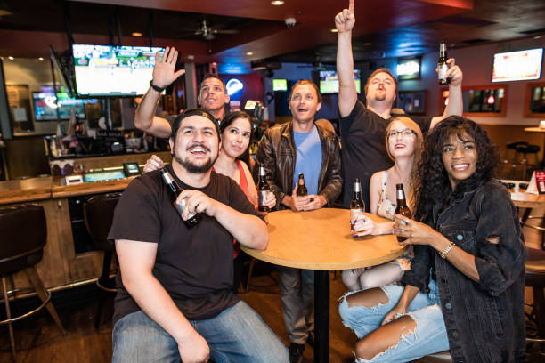 Friends in the bar watching sports and drinking beer stock photo