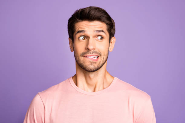 Close-up portrait of his he nice attractive funny confused brunet bearded guy wearing pink tshirt waiting news biting lip isolated over violet purple lilac pastel color background Close-up portrait of his he nice attractive funny confused brunet bearded guy wearing, pink tshirt waiting news biting lip isolated over violet purple lilac pastel color background uncertainty photos stock pictures, royalty-free photos & images