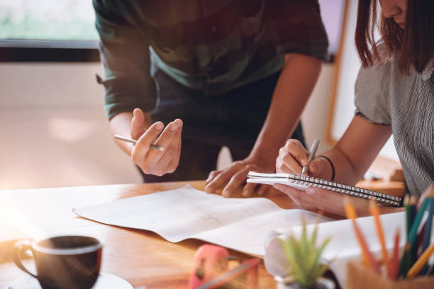 istock Young male and female architect colleagues Design Working Planning project with a blueprint in the office. 1179591045