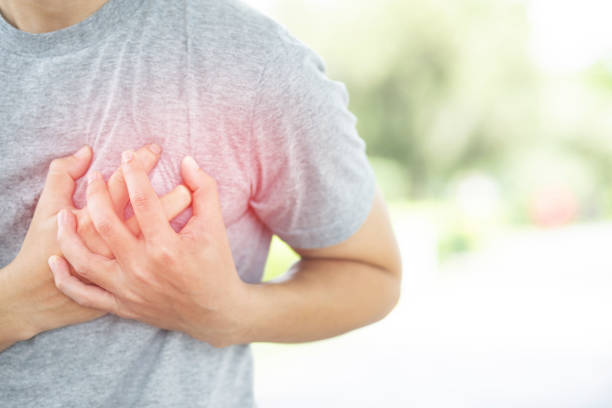Both hands grasp the left chest of a person with chest pain. stock photo