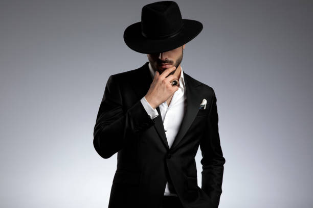 istock mysterious young man wearing tuxedo and black hat 1179592411