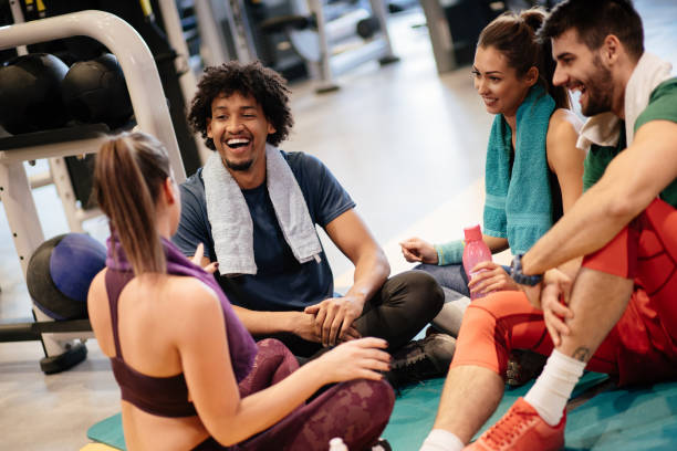 istock Young cheerful people resting from exercising at gym and communicating 1179594356