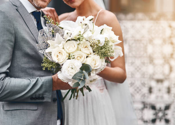To beautiful beginnings Cropped shot of an unrecognizable bride and groom standing together bunch of flowers photos stock pictures, royalty-free photos & images