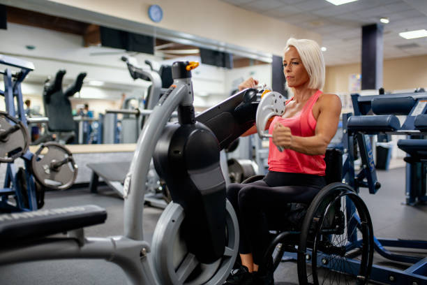 istock Adaptive athlete in a wheelchair using a seated cycling machine 1179595752