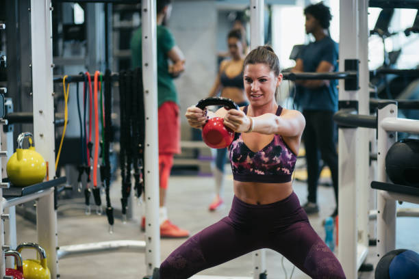 istock Young woman doing kettlebell exercises at gym 1179596307