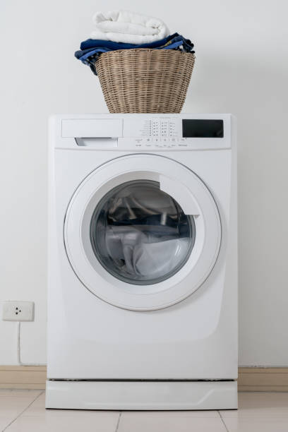 istock Close up washing machine and clothes in basket on white background. Laundry concept. 1179598802