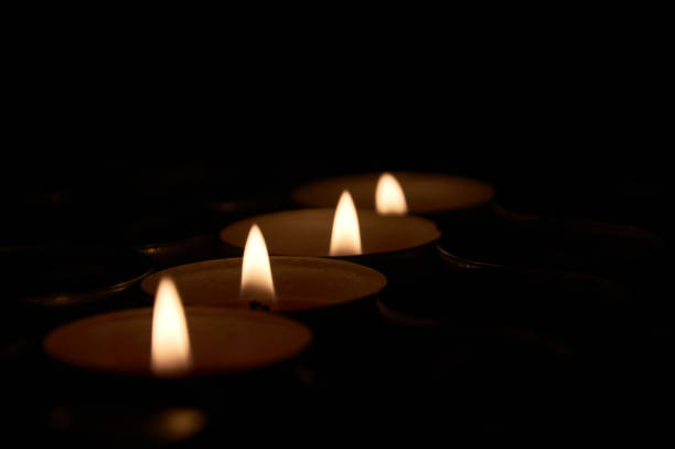 istock Small flames of fire in four candles in line lit 1179599167