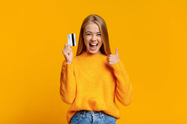 Carefree young girl showing thumb up, excited about upcoming shopping Father's credit card. Carefree young girl showing thumb up, excited about upcoming shopping thumbs up photos stock pictures, royalty-free photos & images