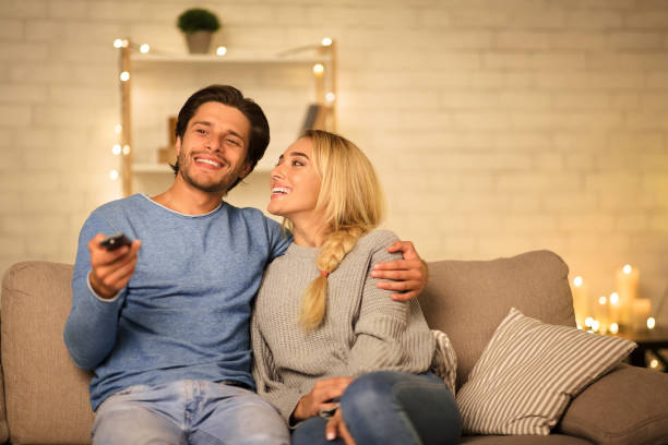 istock Young couple watching TV on sofa in the evening 1179599690